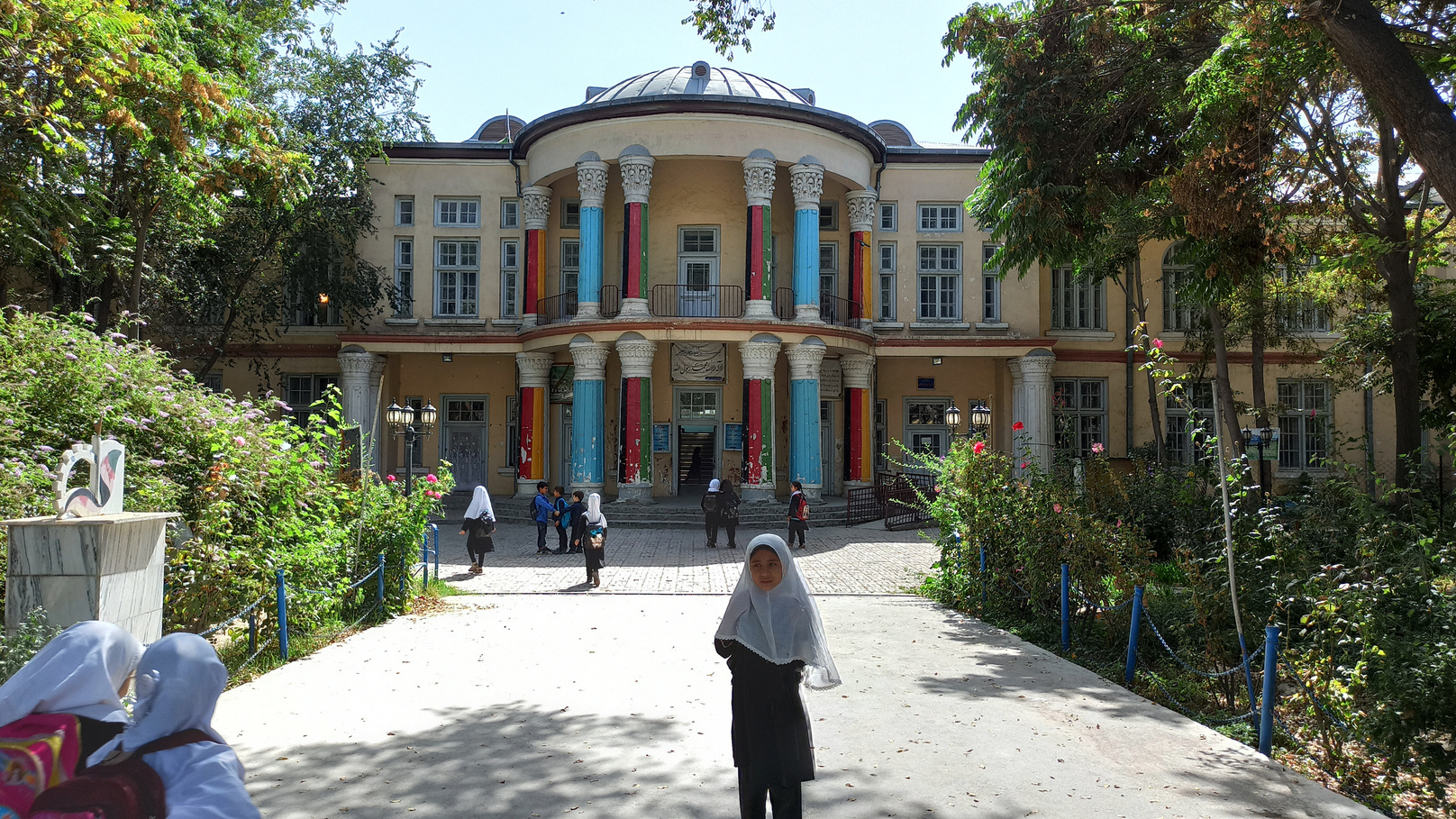 a girl walking outside of a school in Kabul, Afghanistan