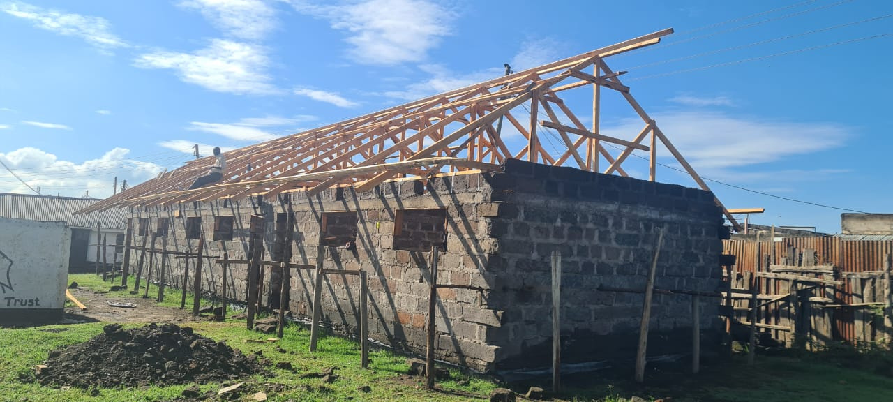 a building under construction with wooden beams on the roof