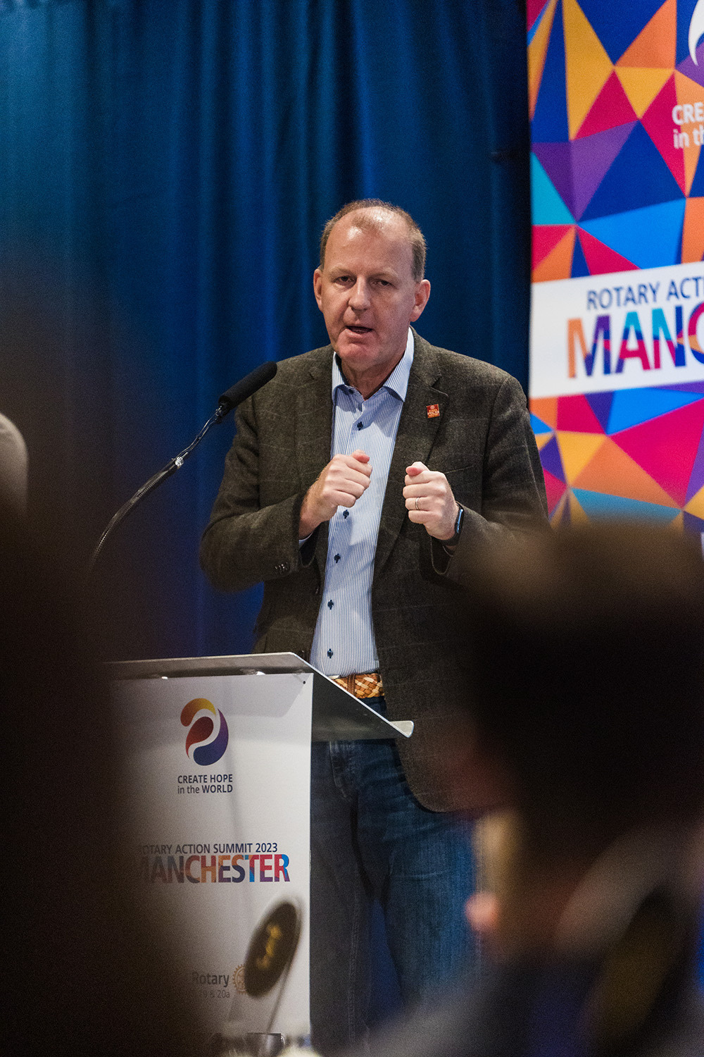 a person speaking into a microphone at a conference