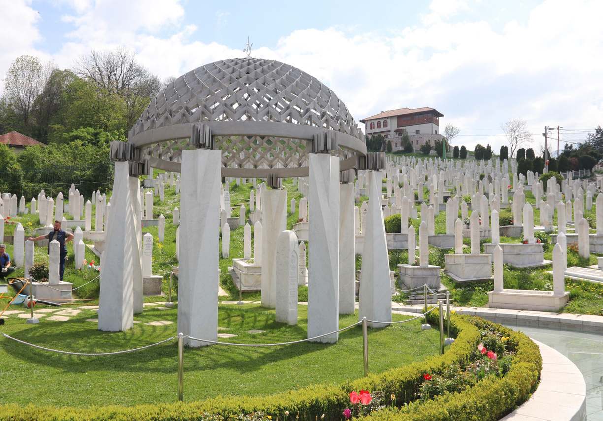 a memorial graveyard on a hillside with dozens of stone graves