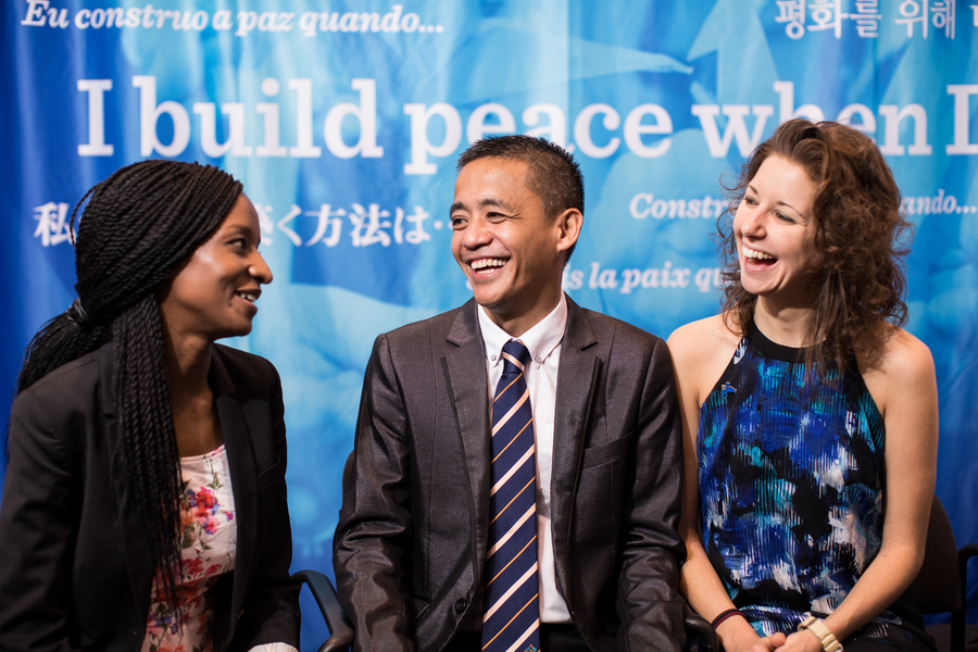 a group of people smiling together in front of a blue banner