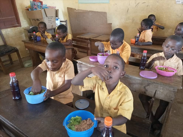 a group of children eating lunch in a classroom