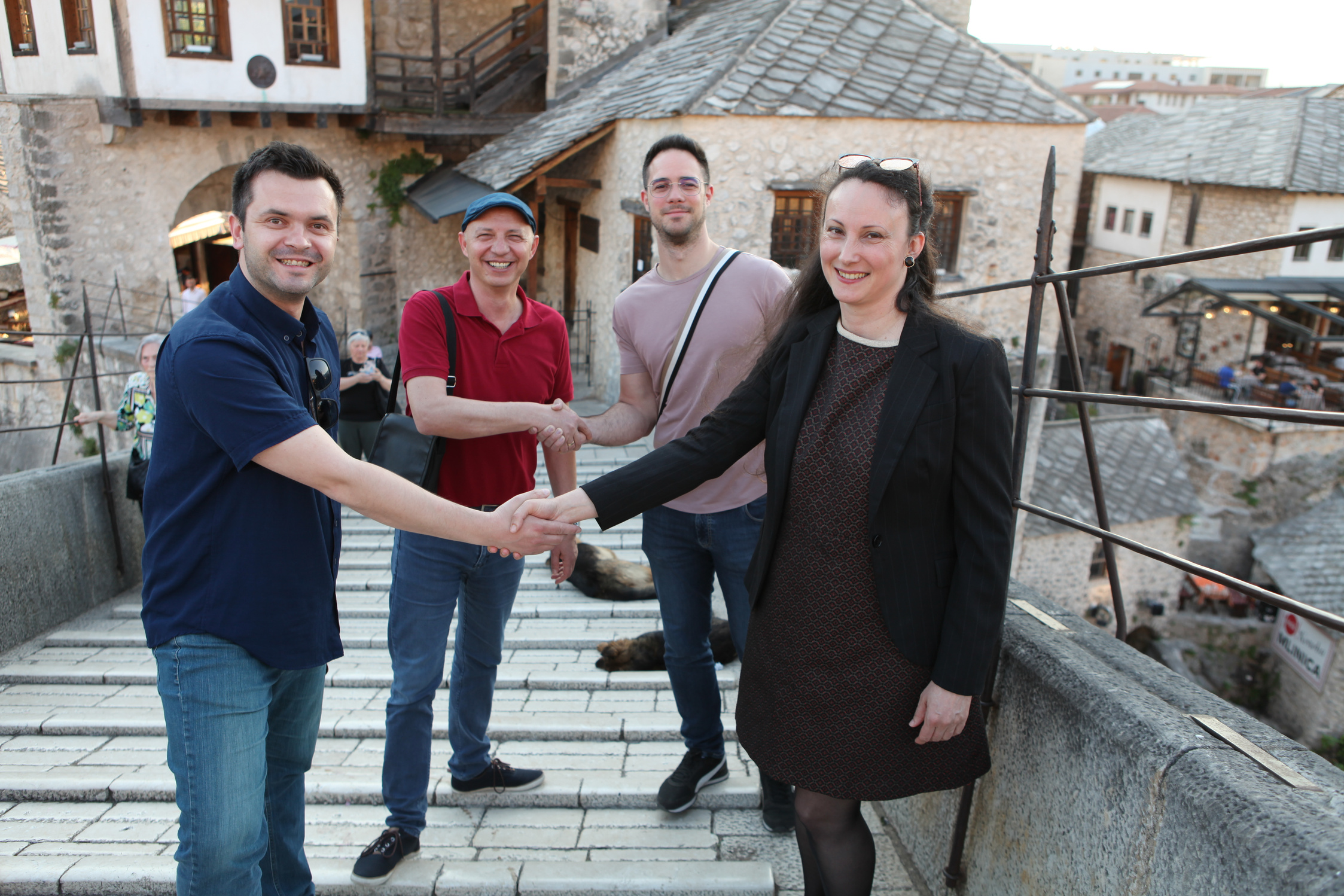 a group of people shaking hands in front of a building