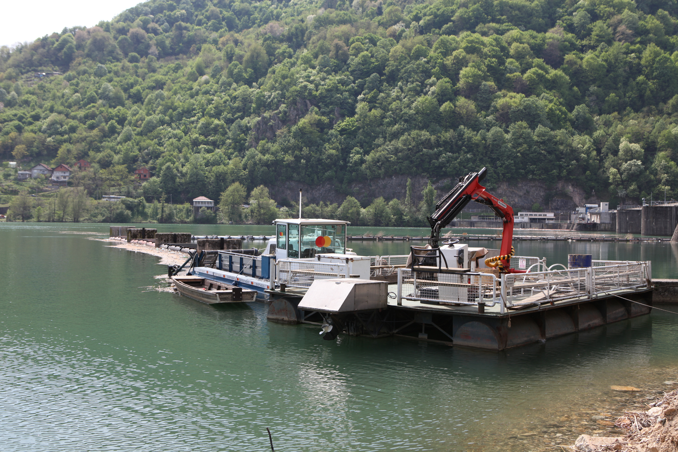 several boats are docked in the water next to a mountain