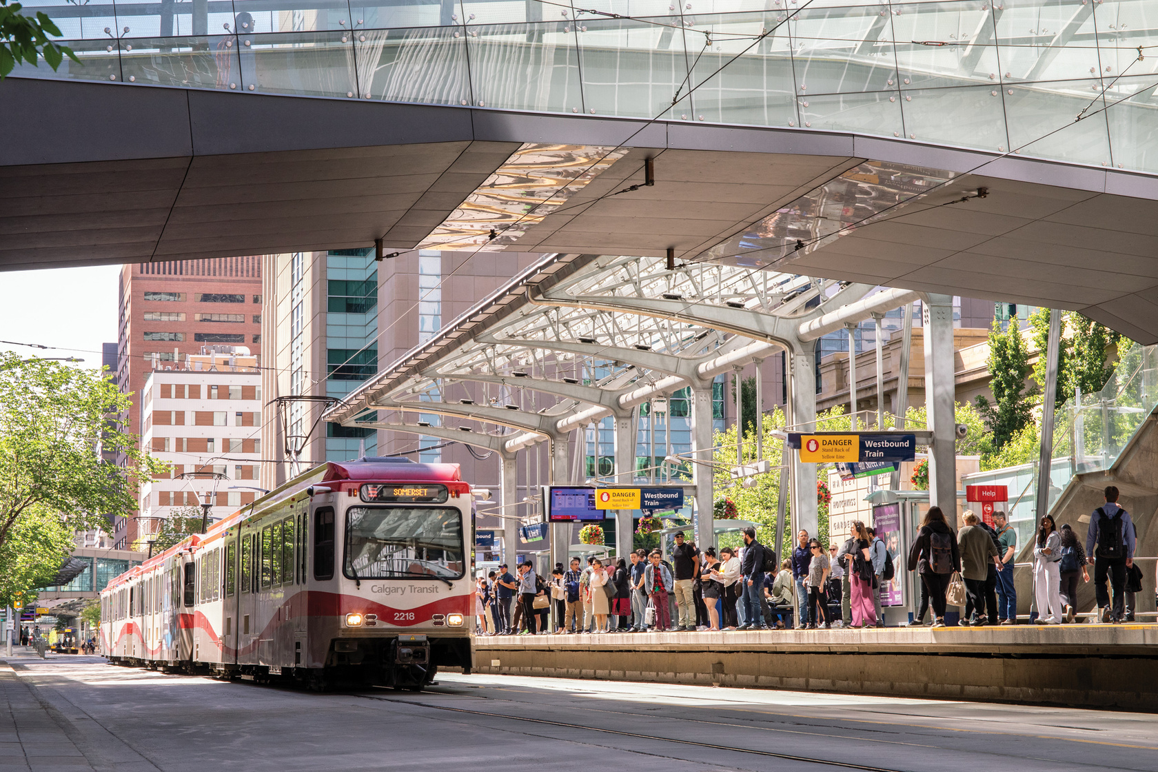 a group of people walking on the sidewalk next to a train