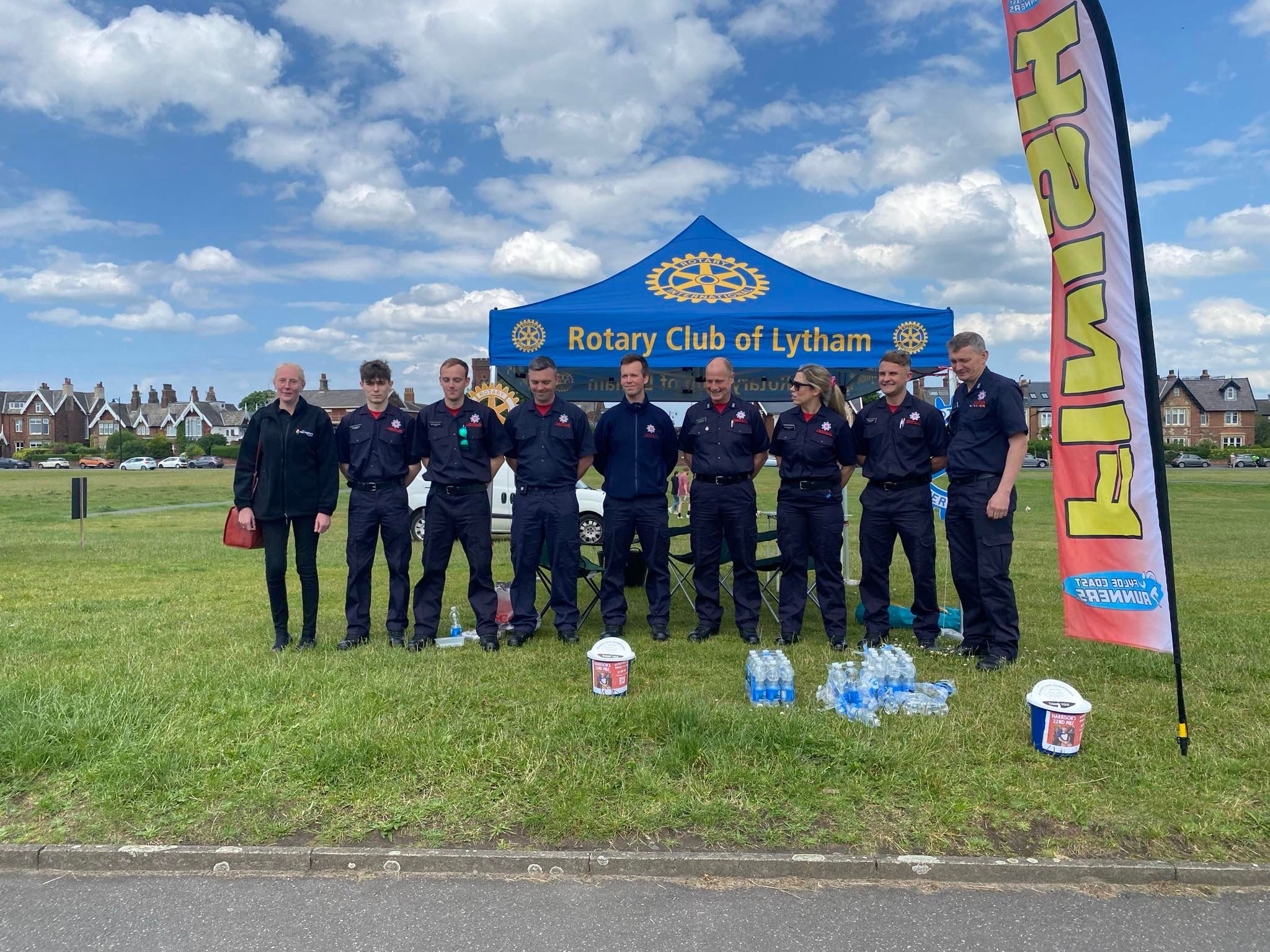 a group of people standing in front of a blue Rotary tent