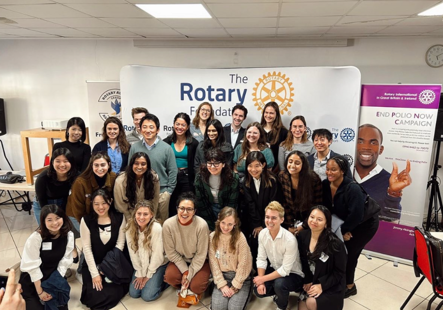 a group Rotary Global Grant scholars posing for a photo in front of a Rotary banner