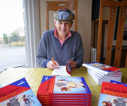 a person sitting at a table with several books in front of them