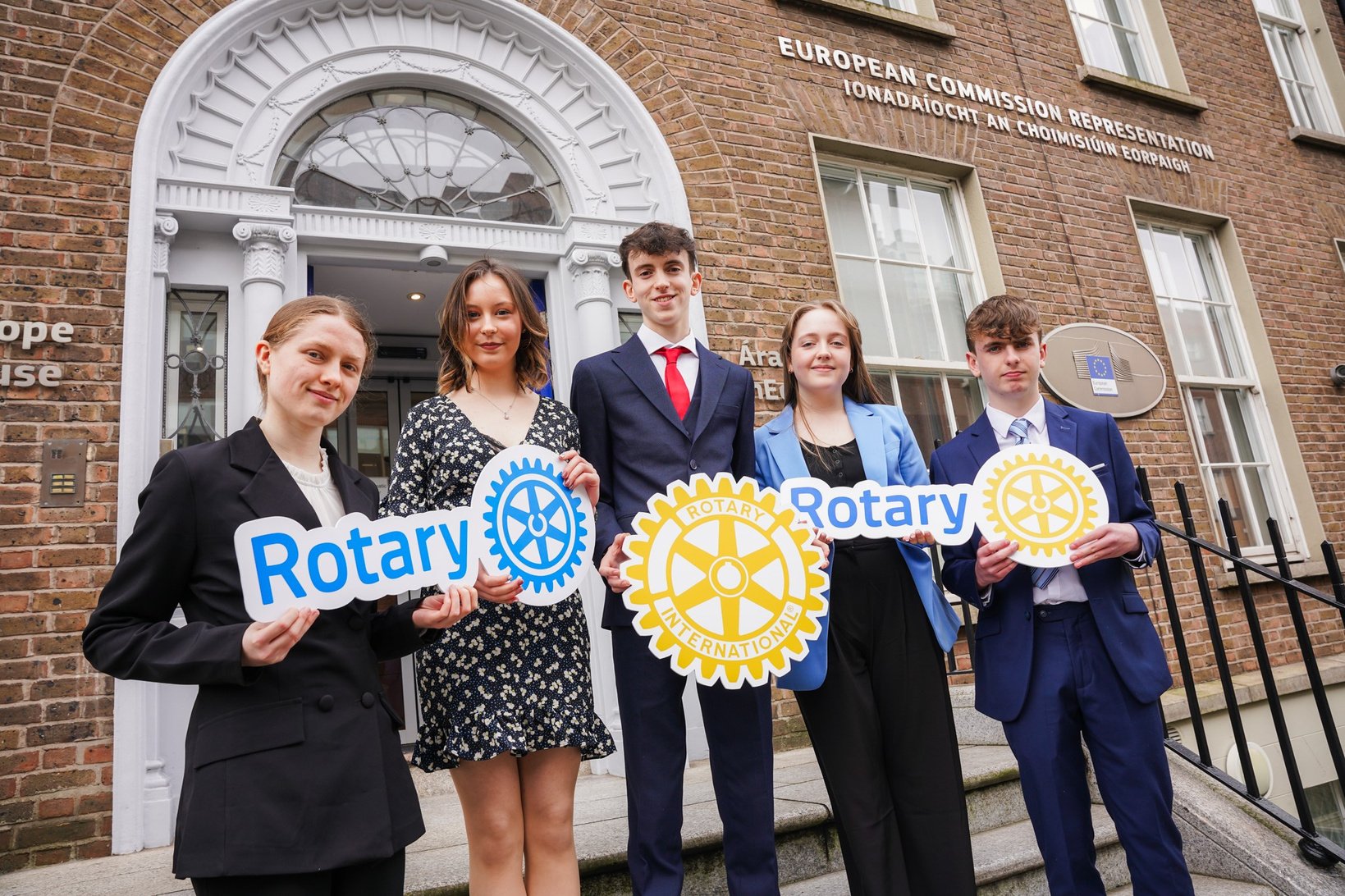 group of young people outside European Commission building holding Rotary signs