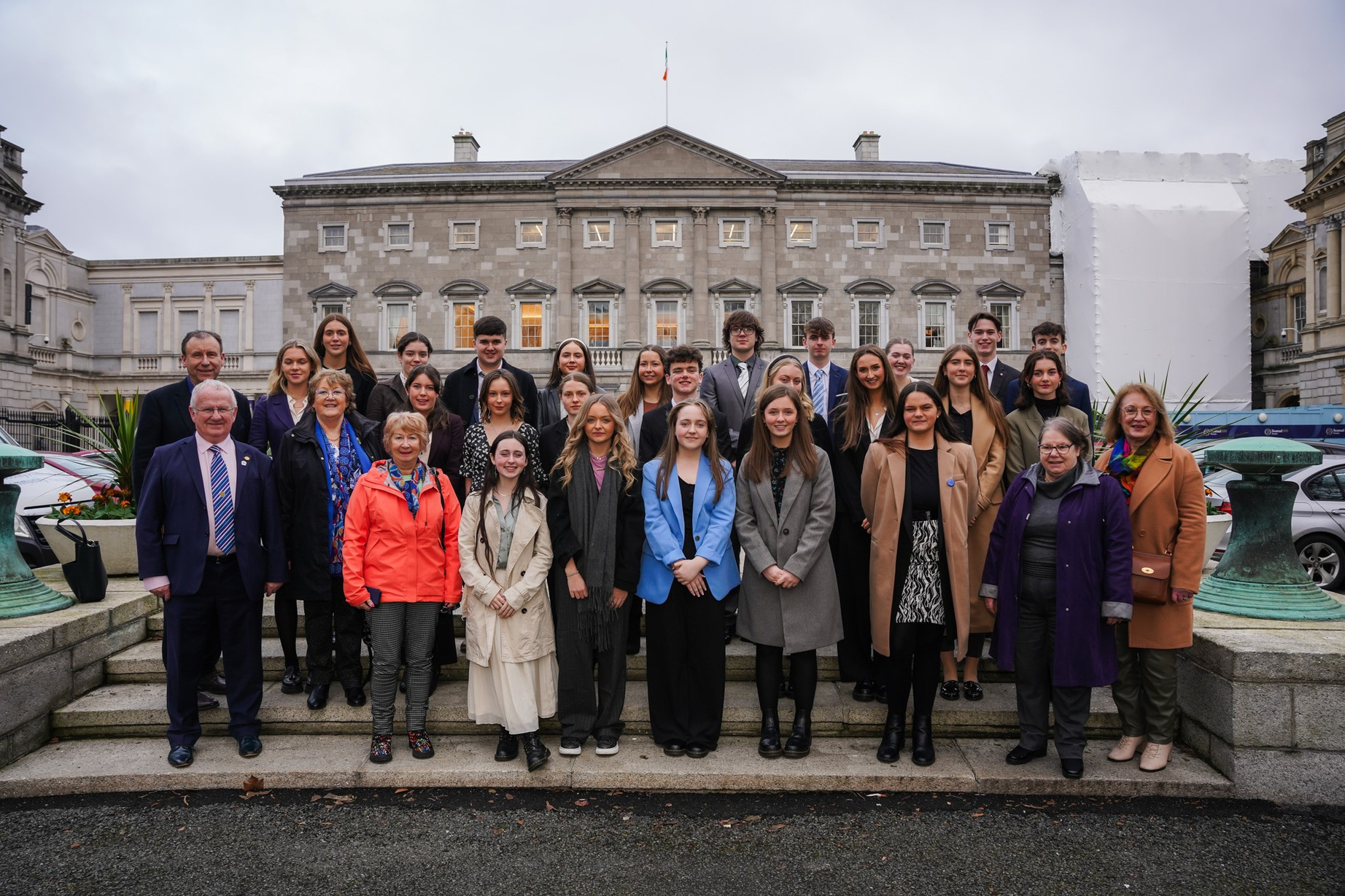 a group of people posing for a photo in front of a building