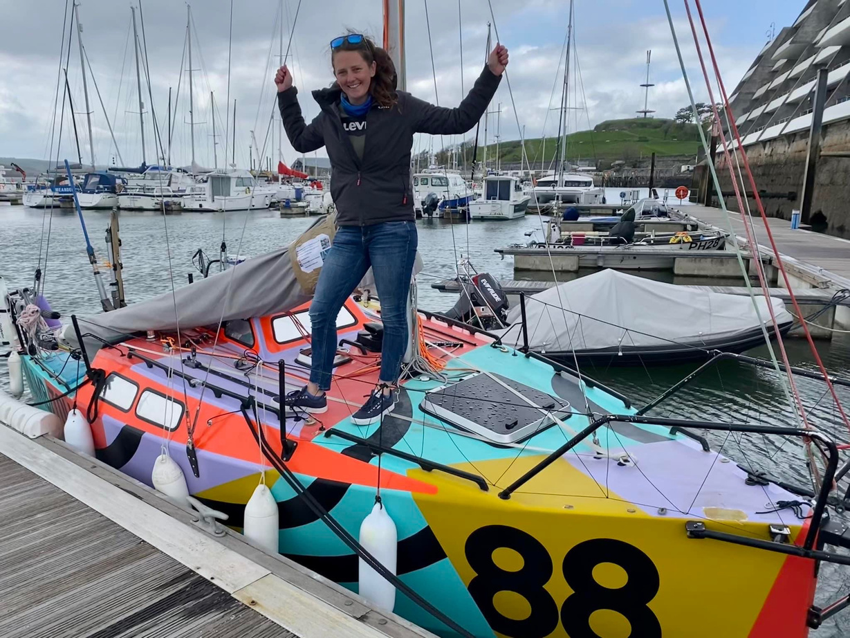 a person standing on top of a colorful sailboat