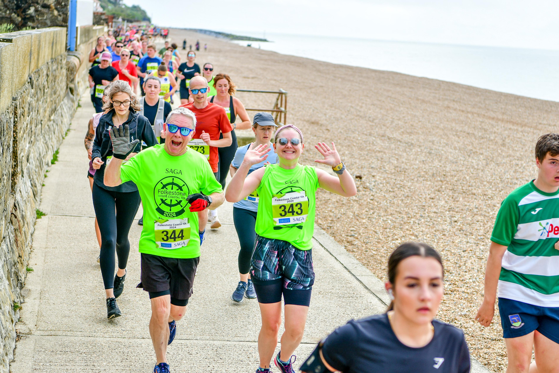 a group of people running on the beach