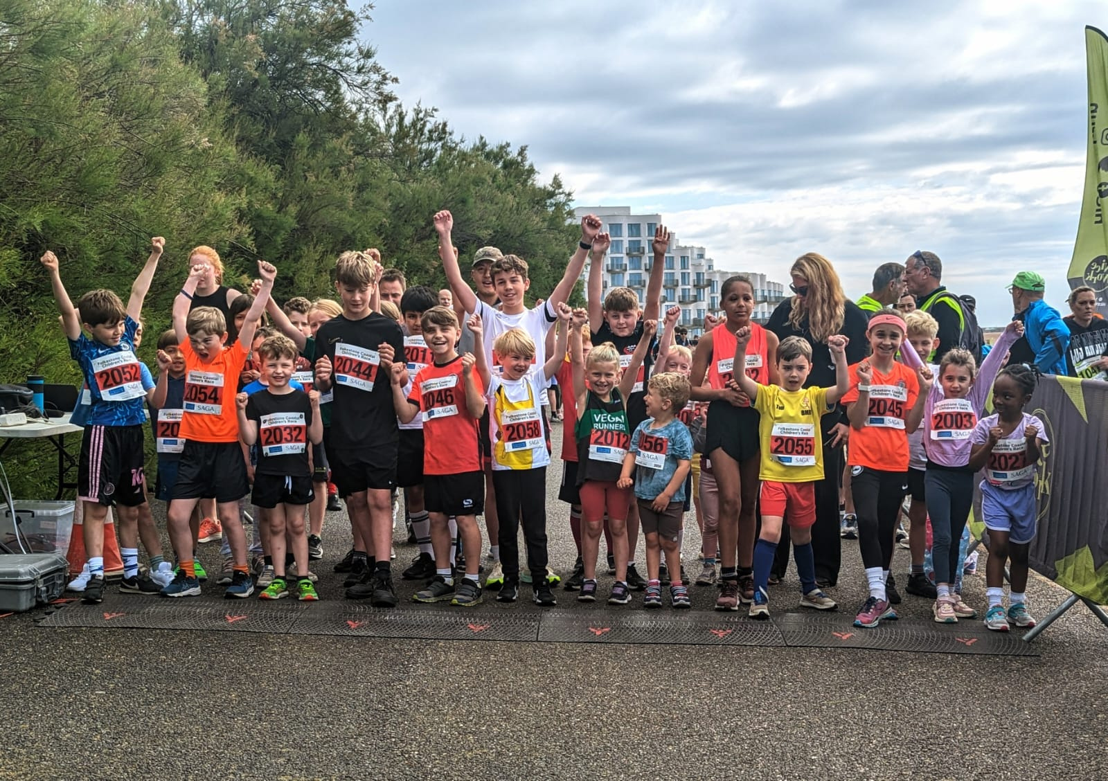 children at the start line of a race with their arms in the air