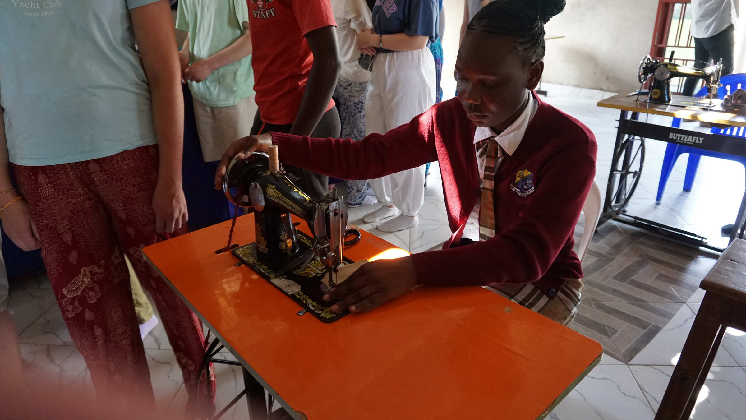 A schoolgirl working on a sewing machine.