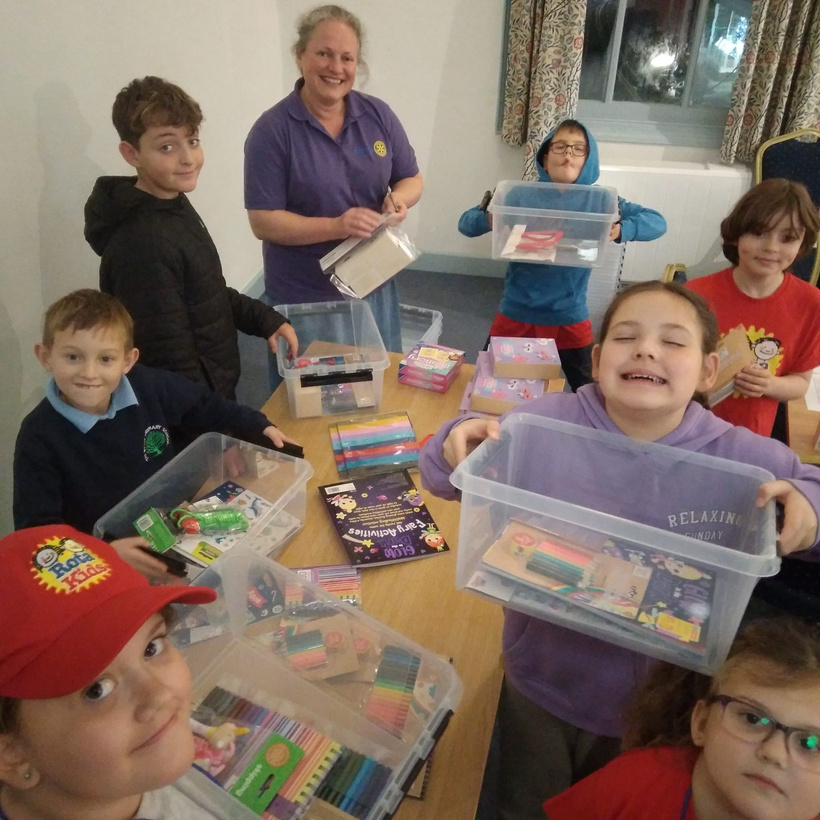 a group of children and adults sitting around a table with toys