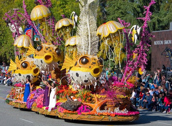 A float that is decorated with flowers and fish.