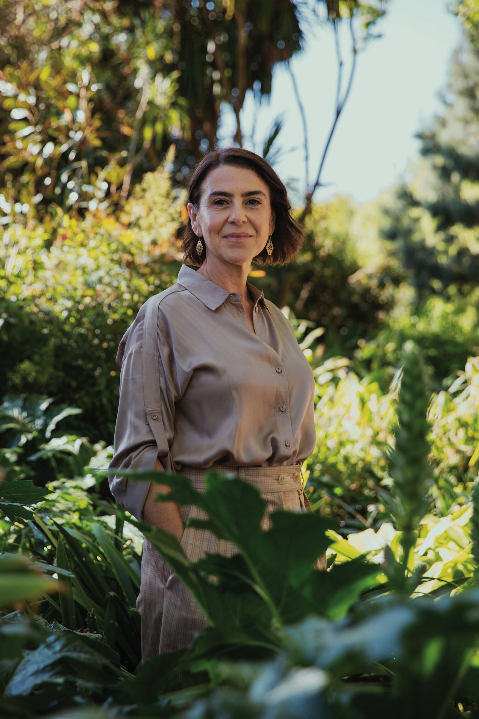 Tania Miletic, Peace Fellow, stands in front of green plants