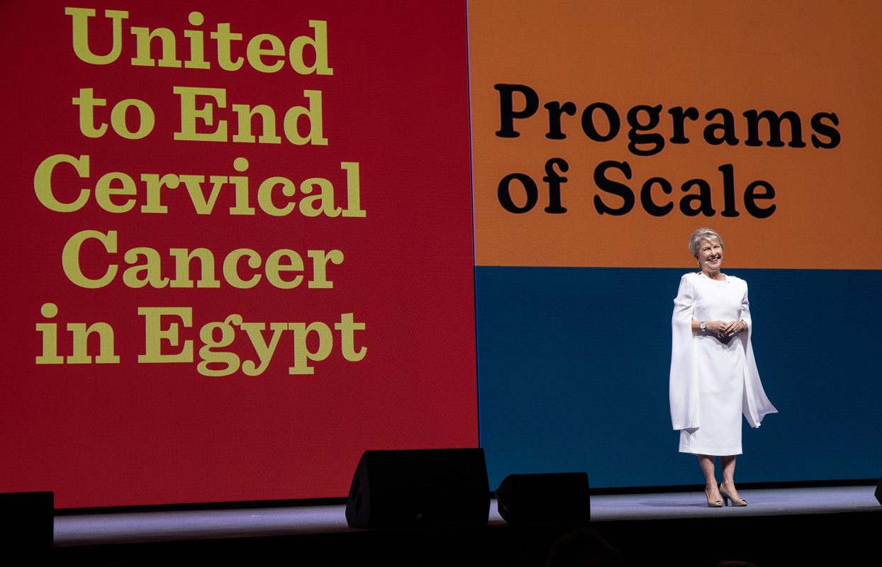 Jennifer Jones stands in front of a sign that says United to End Cervical Cancer in Egypt