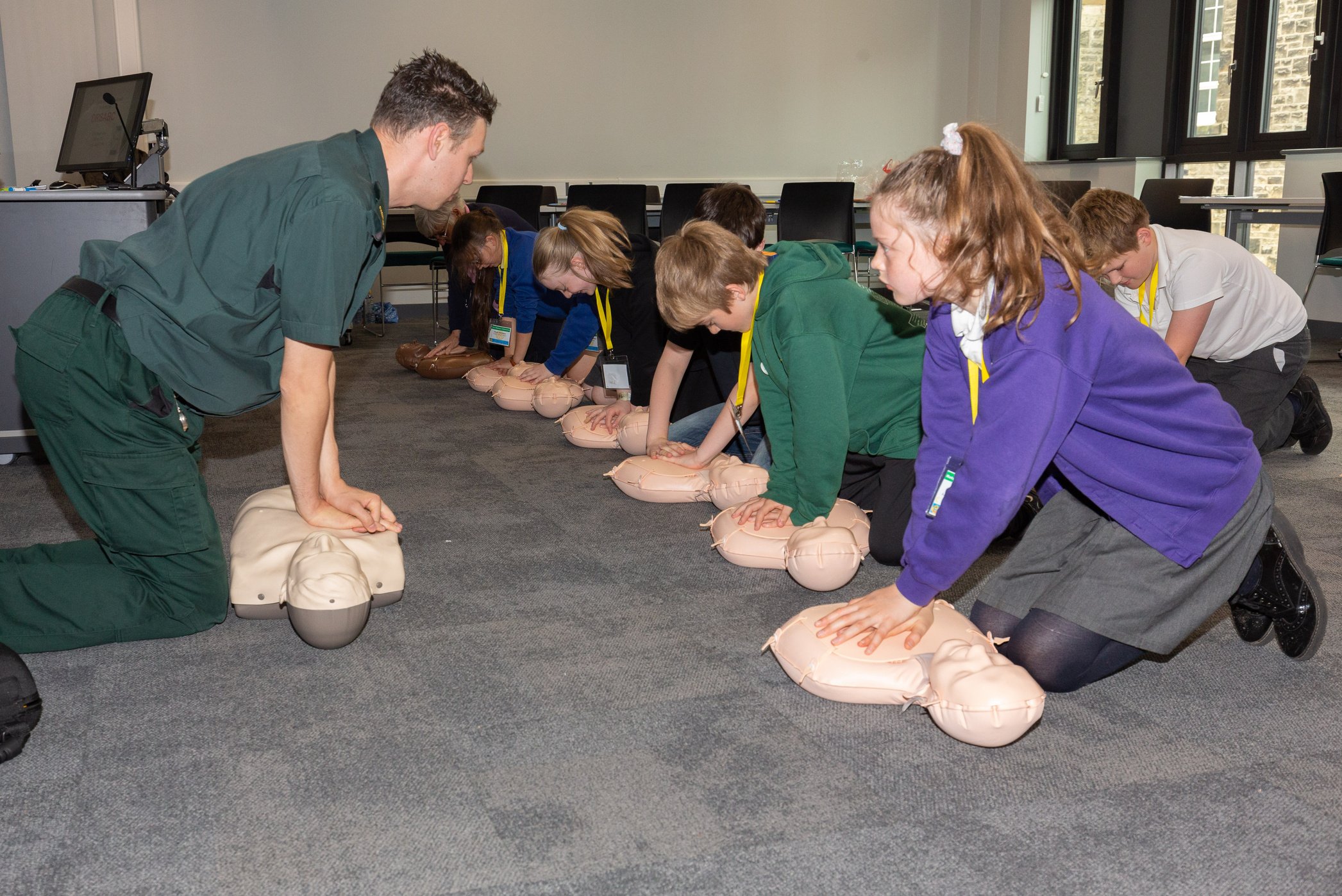 A group of RotaKids learning to do CPR on dummies.