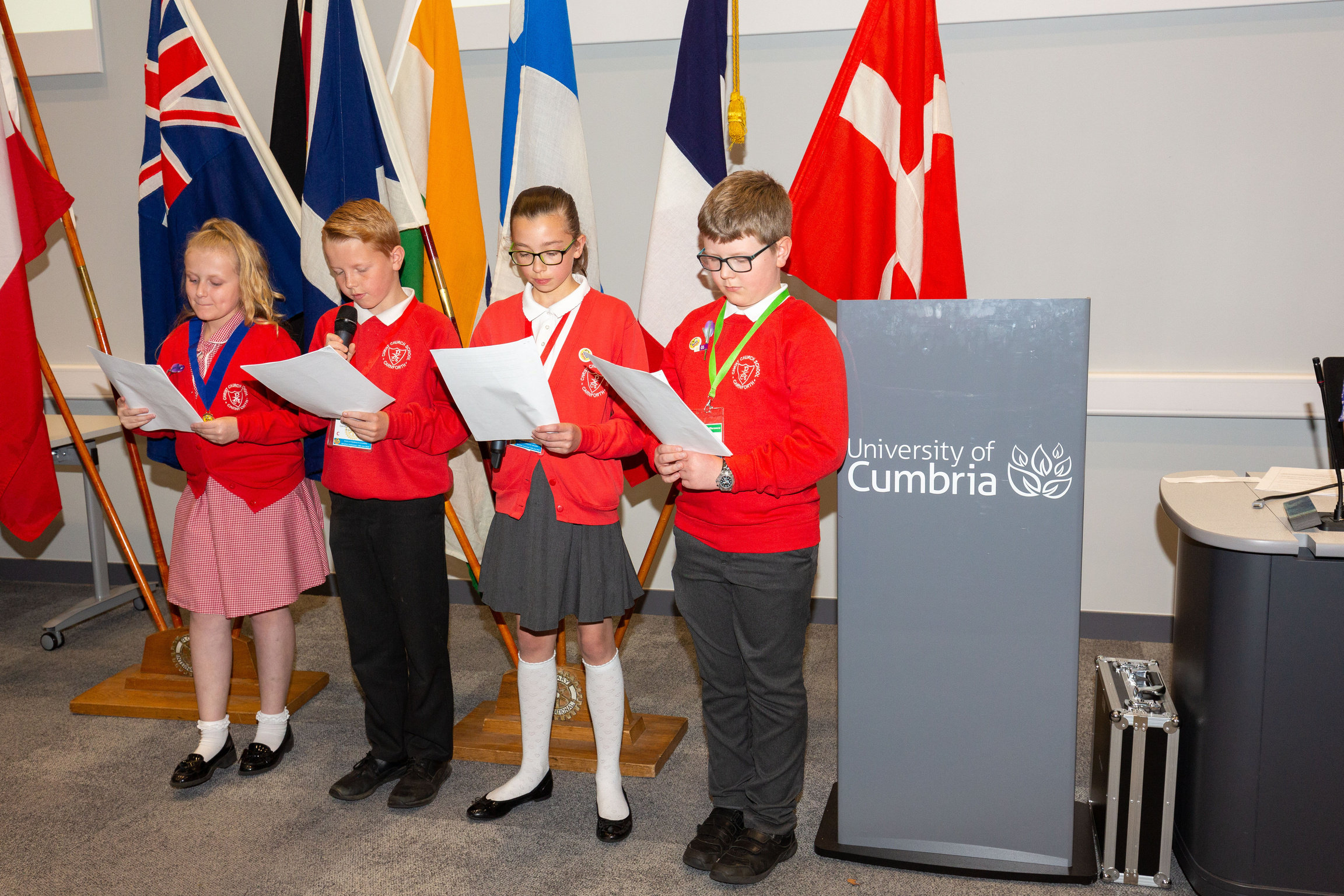 A group of RotaKids standing in front of a podium giving a speech.