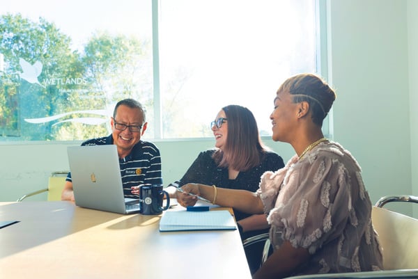 a group of people sitting around a table in an office