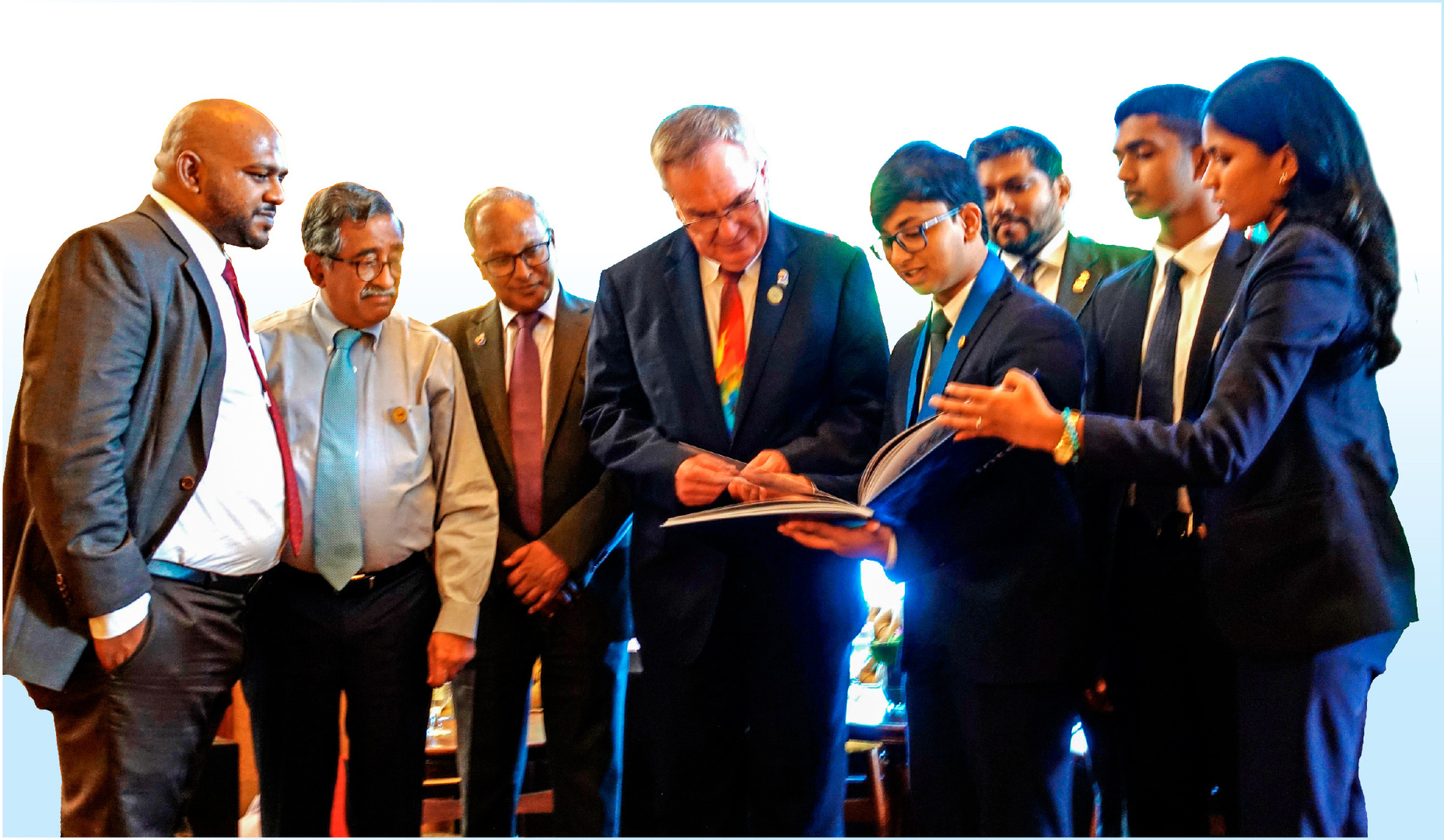 a group of people in suits and ties looking at papers