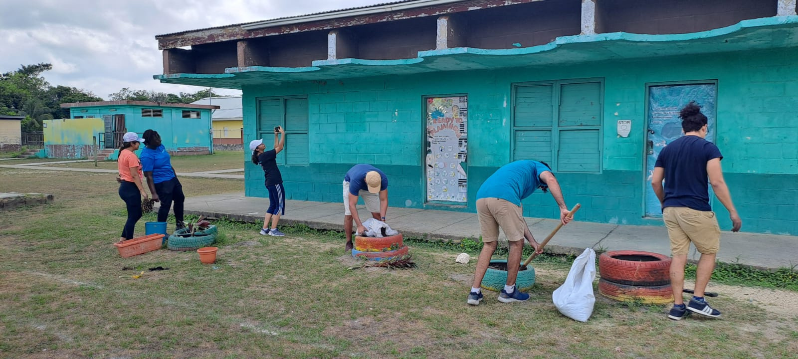 A group of volunteers refurbishing a blue school building