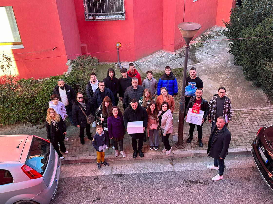 a group of people standing in front of a red building