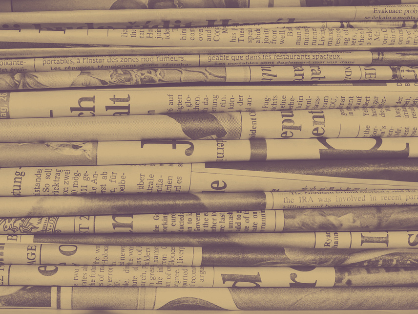 a brown and beige background of a pile of newspapers