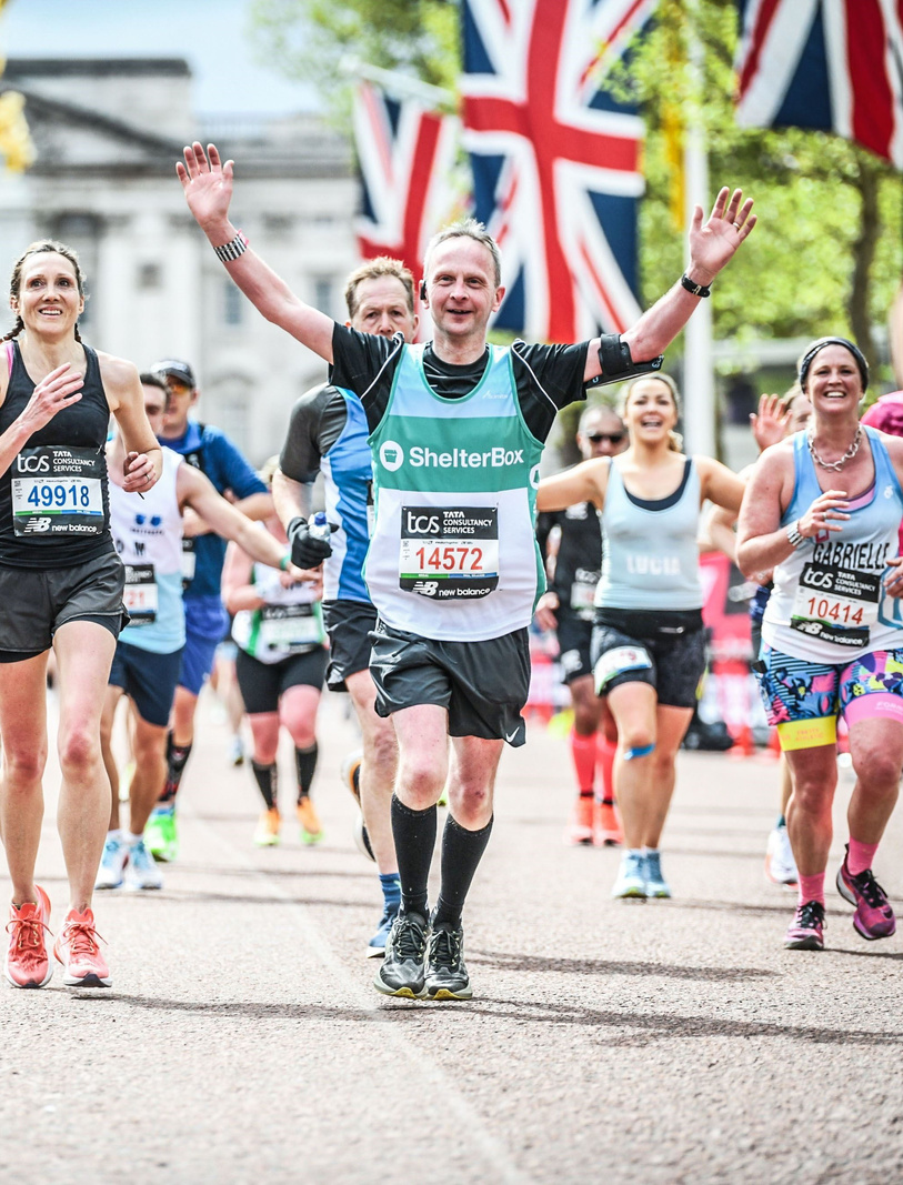 a person running in a marathon with their arms up in the air