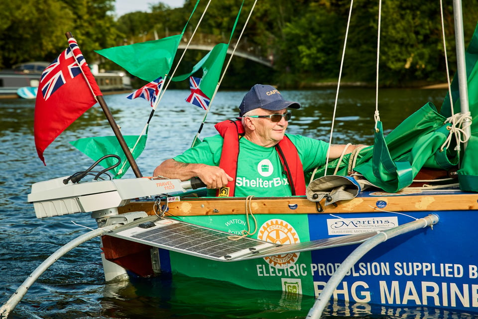 a man sits in a sail boat made from ShelterBoxes