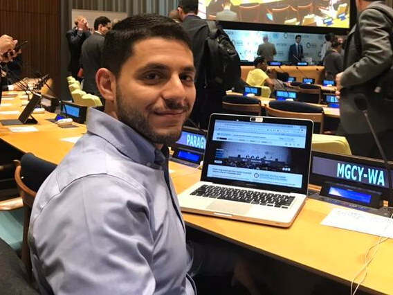 Mohammed Eid sitting at the United Nations Economic and Social council youth forum in front of a laptop