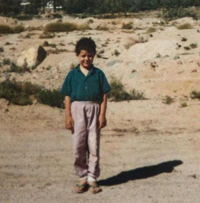 Mohammed Eid as a young boy standing in the middle of a desert