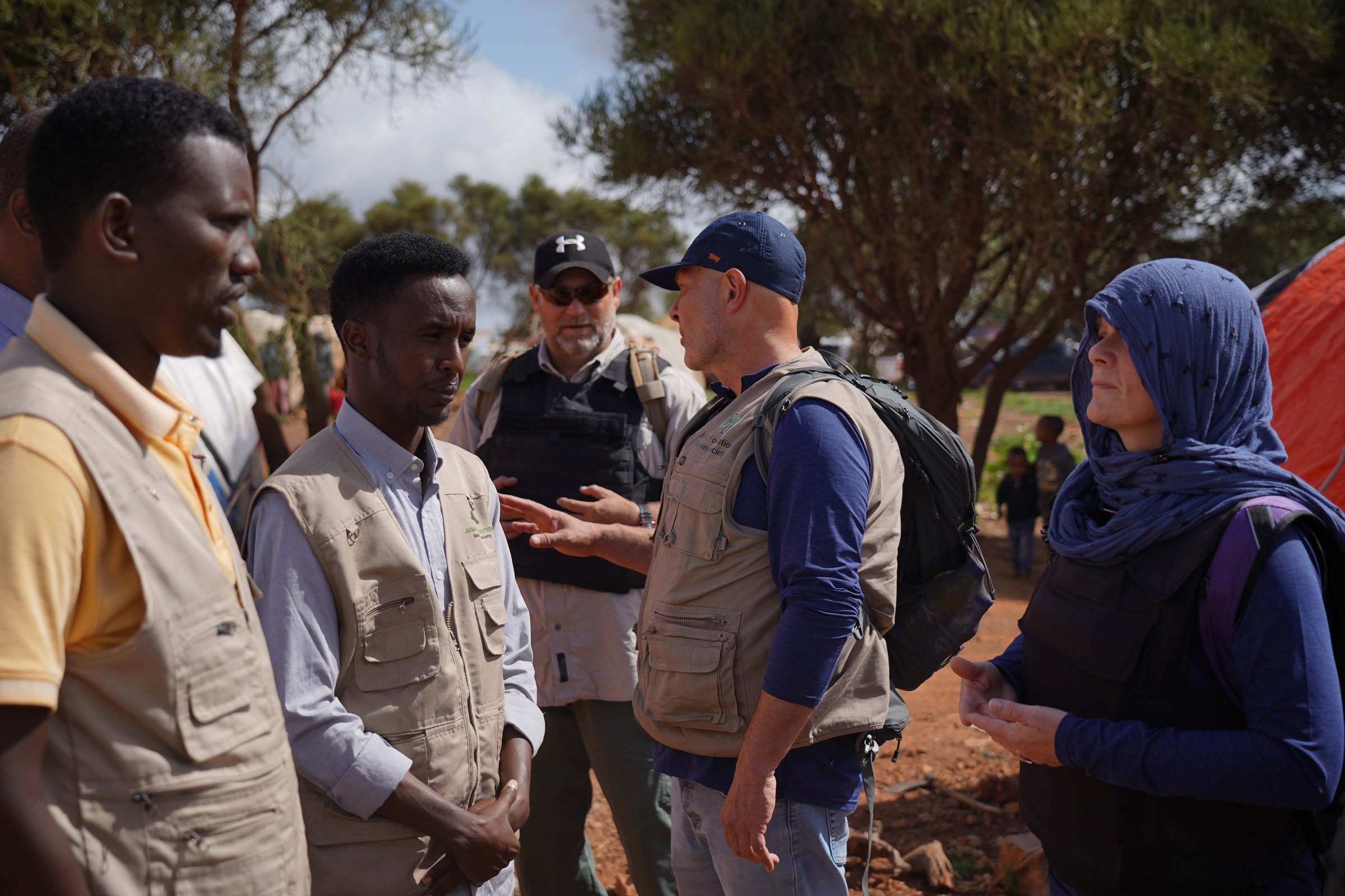 Shelterbox volunteers speaking to local people in an African desert setting