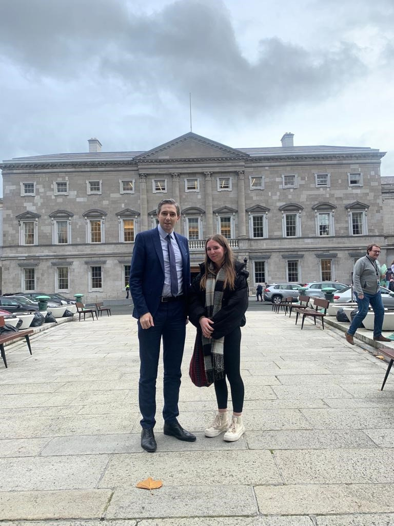 Simon Harris stands with teenage girl outside Irish parliament building