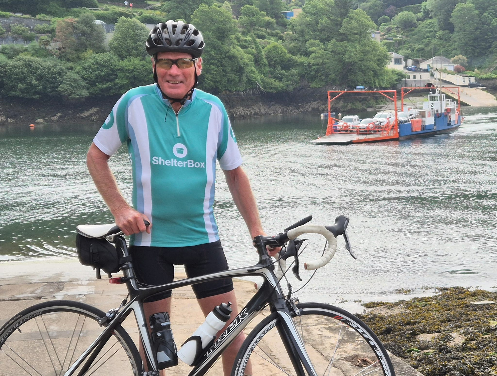 a person with a bike standing next to a body of water