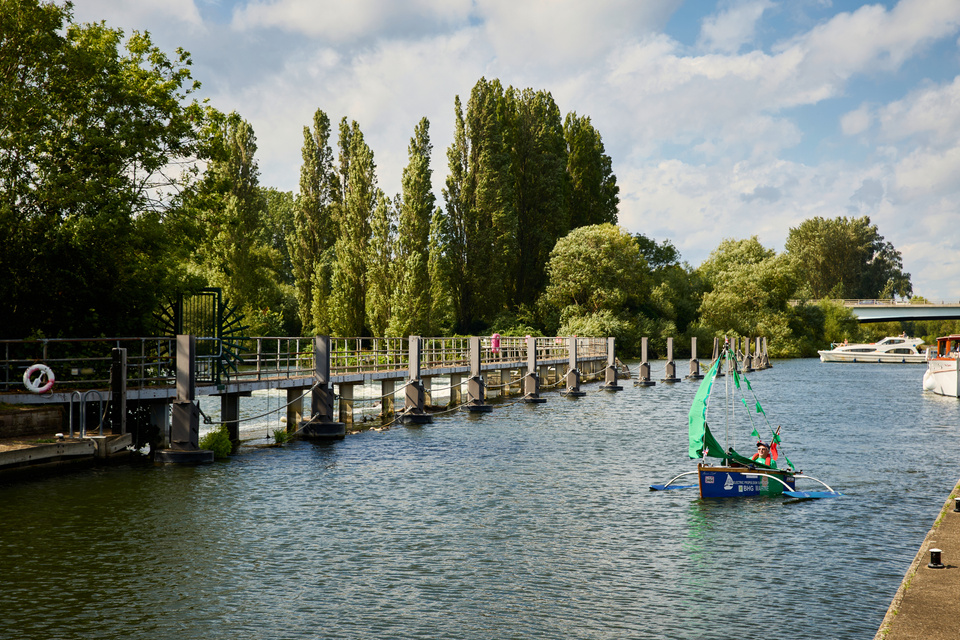 a small sailboat is on the water in front of a dock