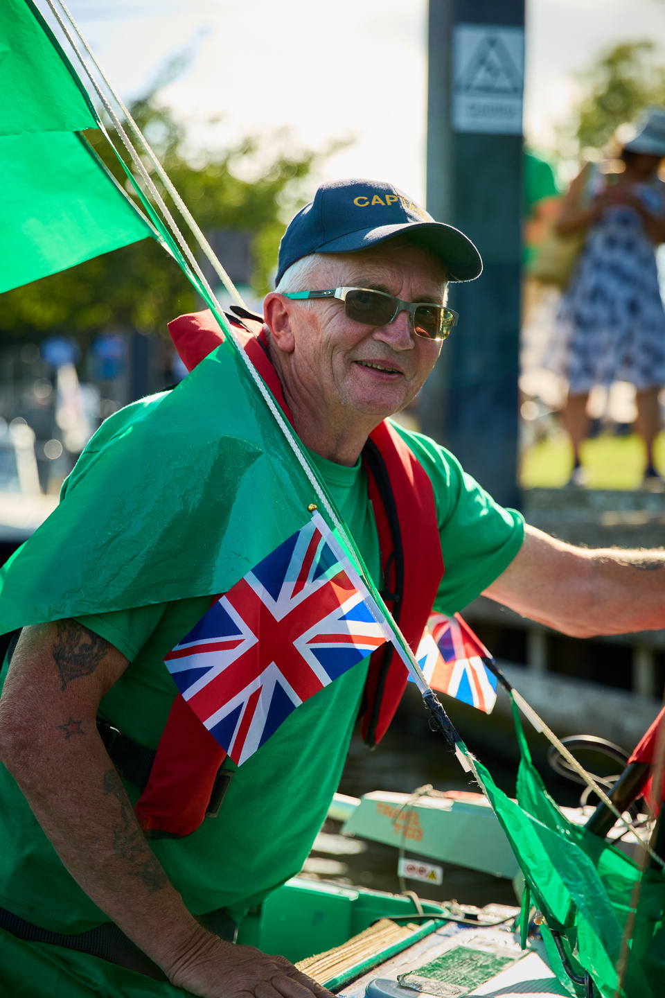 a person in a green shirt holding a flag on a boat