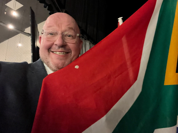 a person in a suit holding a South Africa flag