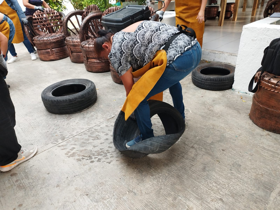 a person bending over a tire with a yellow apron