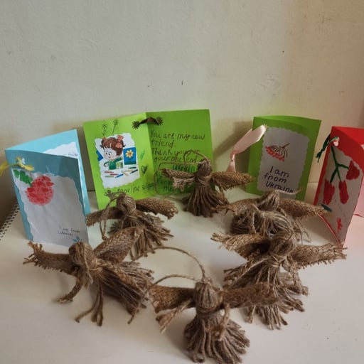 A group of Christmas ornaments and cards sent to children in Ukraine sitting on top of a table.