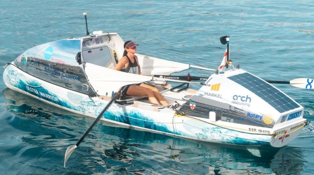 a person is rowing in a boat with solar panels on it