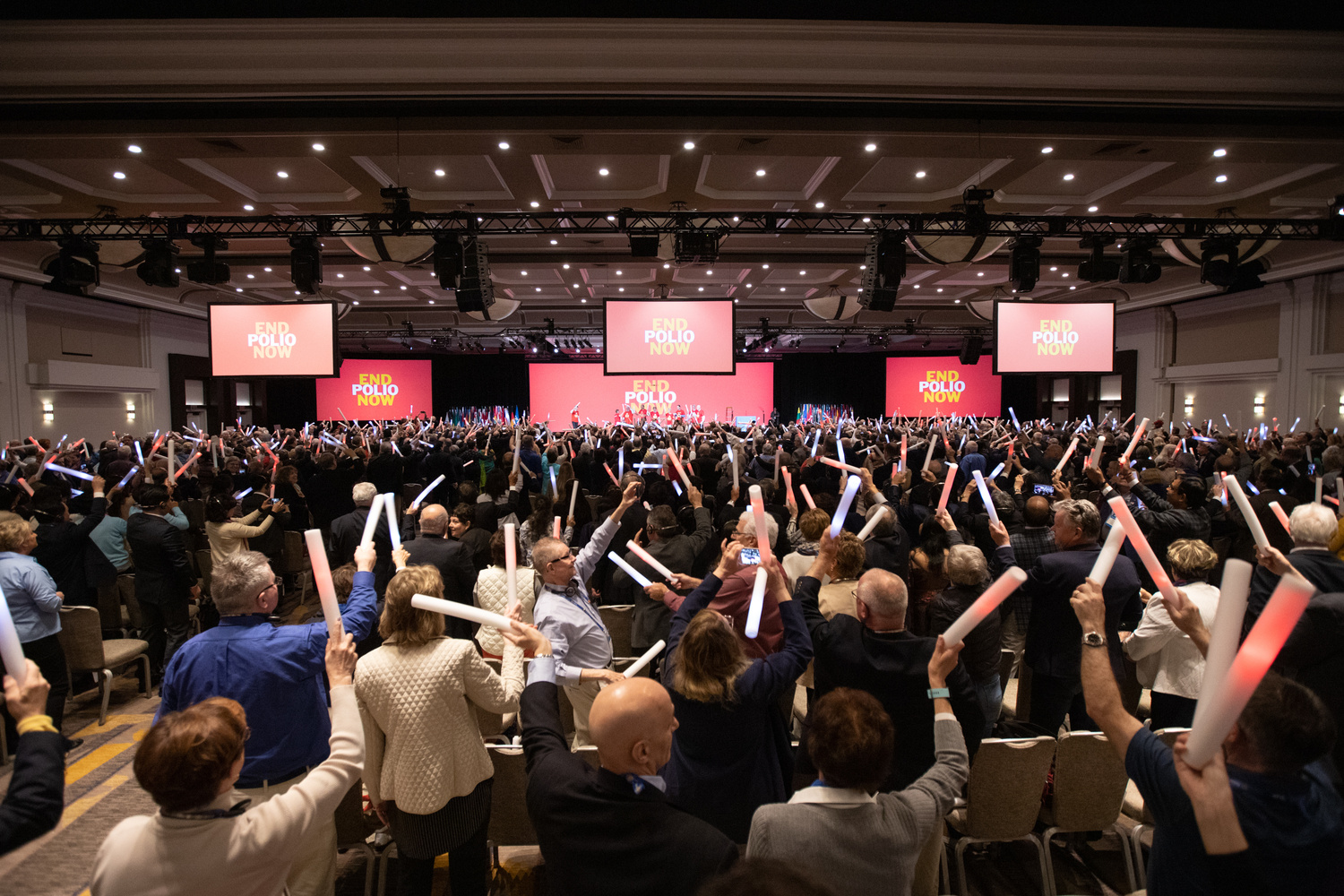 People in a conference hall celebrate the announcement that Rotary and the Bill & Melina Gates Foundation will extend their fundraising partnership to eradicate polio